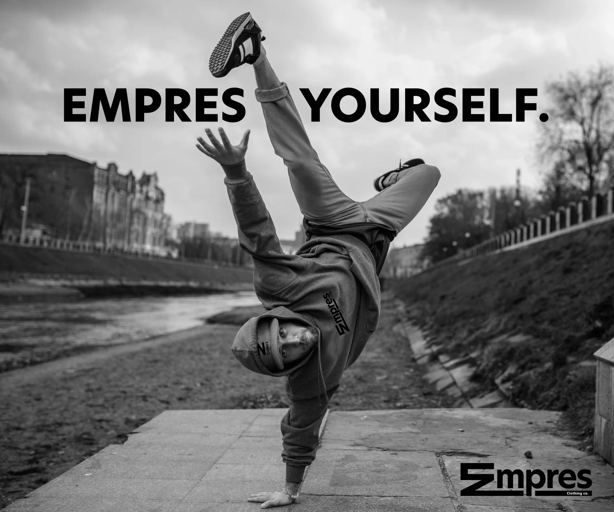 Black and white campaign photo: a breakdancer in an Empres hoodie holds a one-handed freeze, with the headline EMPRES YOURSELF.